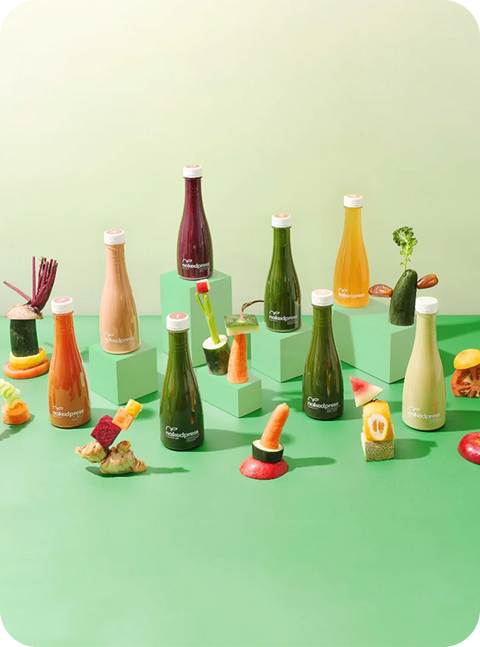 Botol-botol jus nakedpress dikelilingi buah dan sayur segar — brand F&B klien Shopex